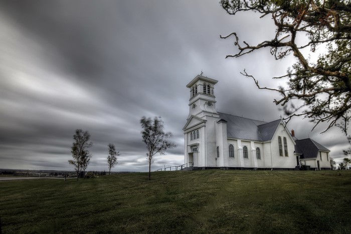 White church on a hill under an overcast sky in Prince Edward Island, Canada