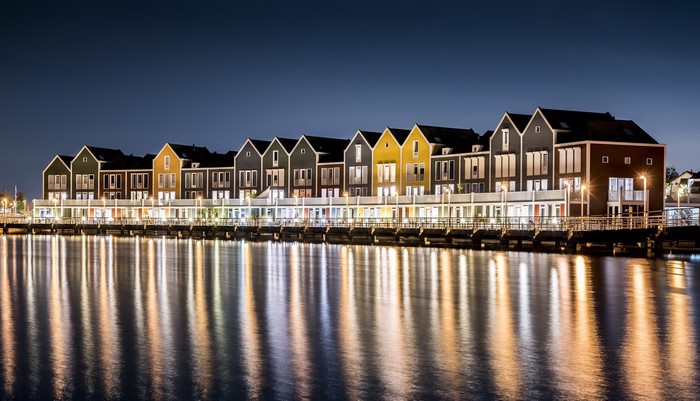 Colorful houses reflected in water at night