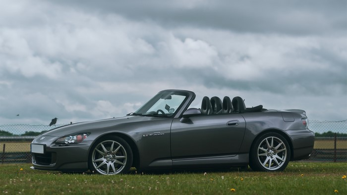 Gray Honda S2000 convertible parked on grass