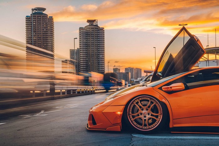 Orange Lamborghini Diablo with Scissor Doors in Cityscape at Sunset