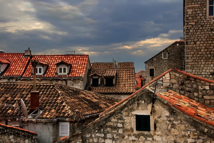 Rooftops of an old European town under a cloudy sky