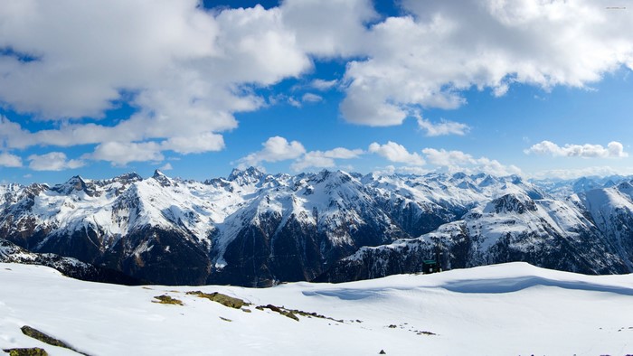 Snow covered Alps mountains with clouds