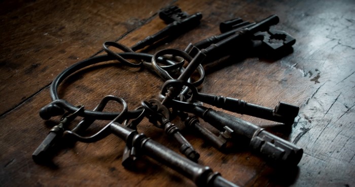 A bunch of old keys on a wooden table