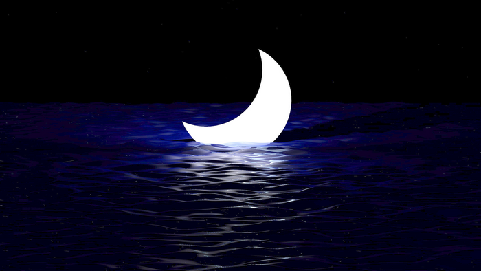 Crescent moon over dark ocean at night