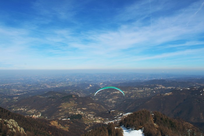 Paraglider over mountains in Italy