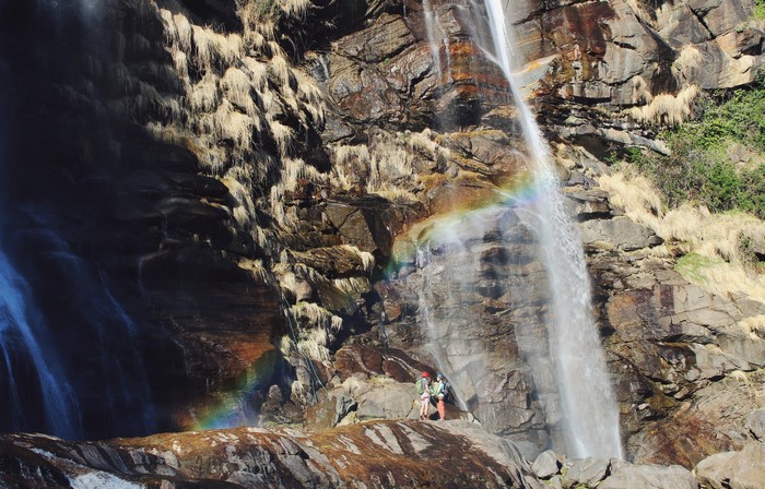 Two people rappelling down a waterfall in Italy