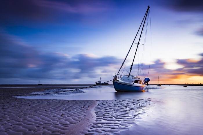 Sailboats on a beach at sunset