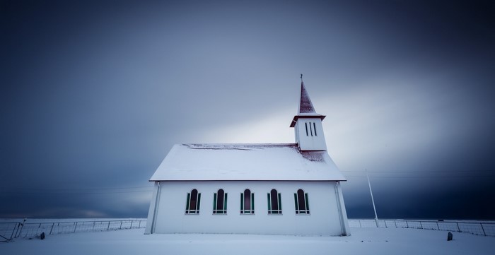 White church in snow under overcast sky in Iceland