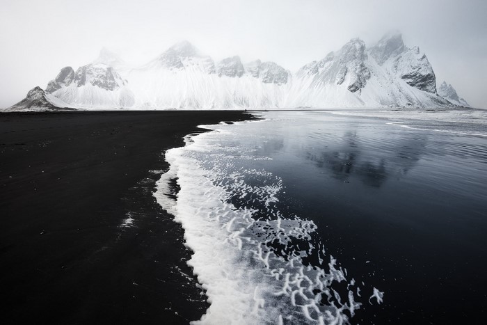Snow-capped mountains and black sand beach in Iceland