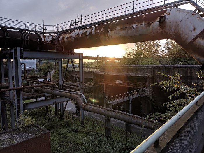 Abandoned factory with rusty pipes and plants in Germany