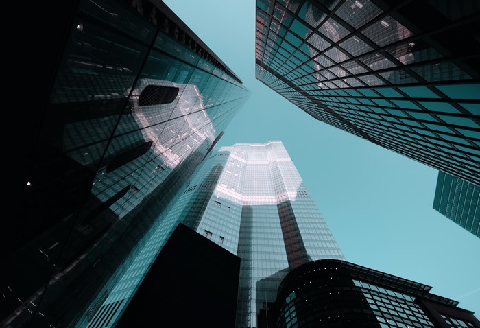 Low-angle view of skyscrapers against a clear cyan sky