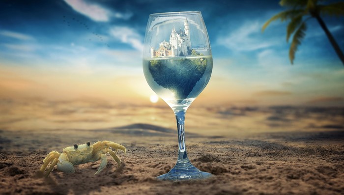 Castle inside a wine glass on a beach with a crab