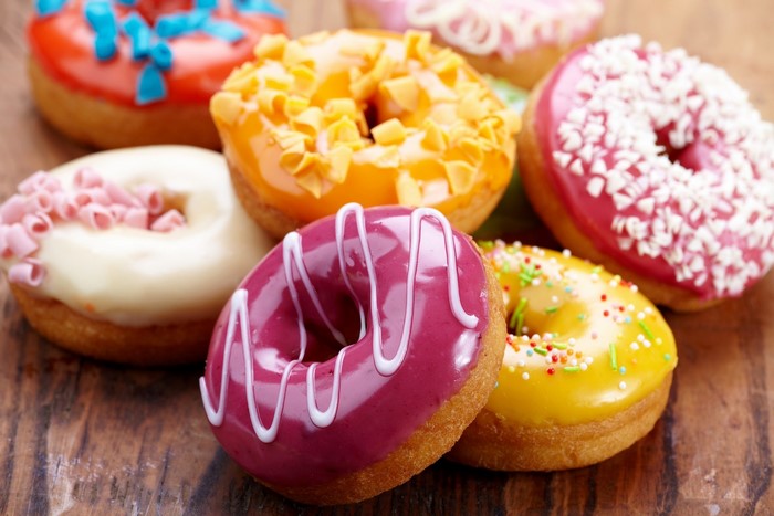 Assortment of colorful donuts on a wooden surface
