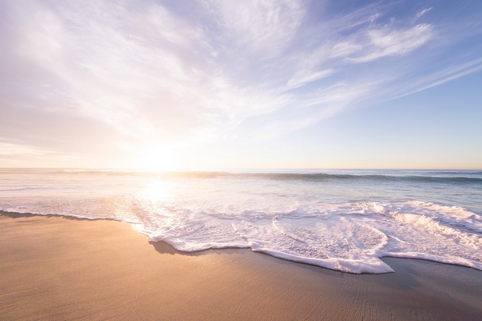Sunset over the ocean with waves on the beach