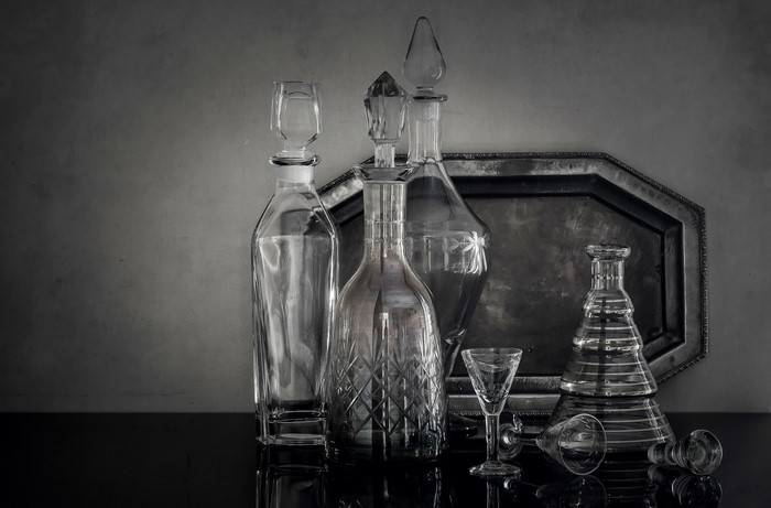 Still life of glass bottles and decanters on a tray