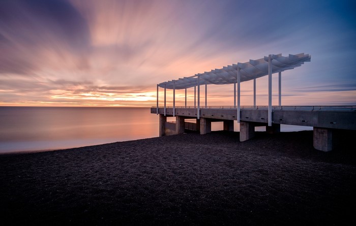 Pier on a beach at sunset