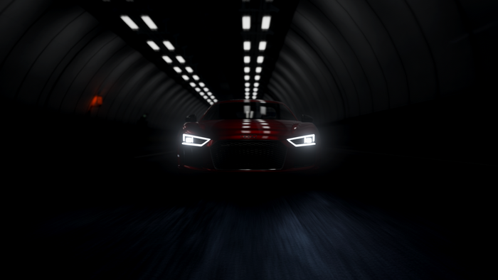 Red Audi R8 driving through a dark tunnel