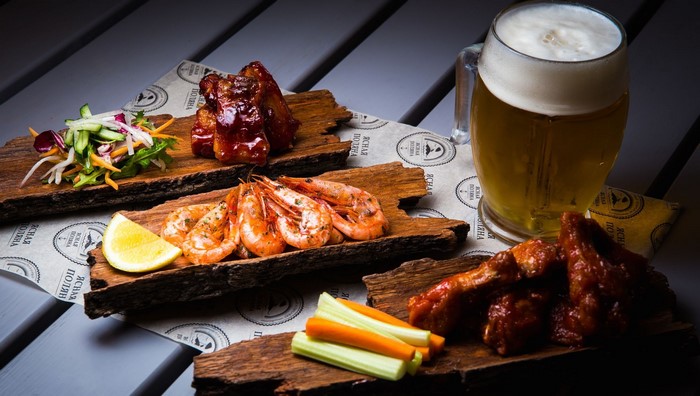 Beer with shrimp, chicken wings, and vegetables