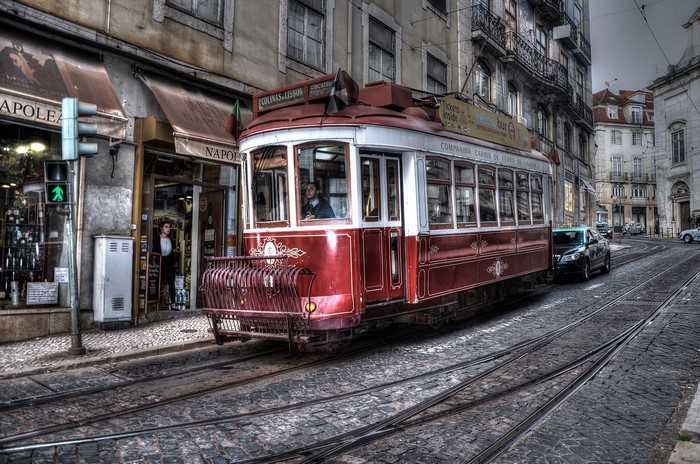 Red tram on cobblestone street in Lisbon, Portugal