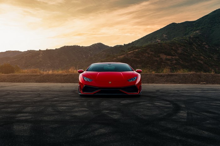 Red Lamborghini Huracan on a road with mountains