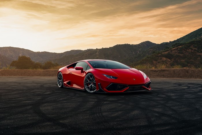 Red Lamborghini Huracan on a road with mountains