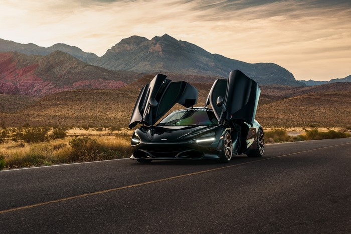 Black McLaren 720S with butterfly doors on a desert road