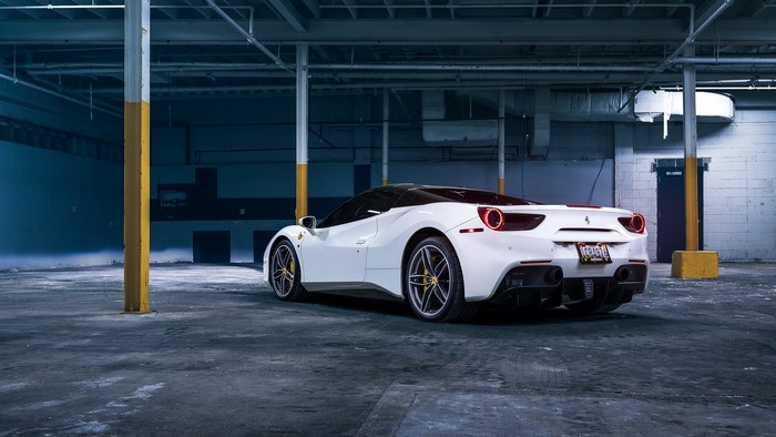 White Ferrari 488 parked in a warehouse
