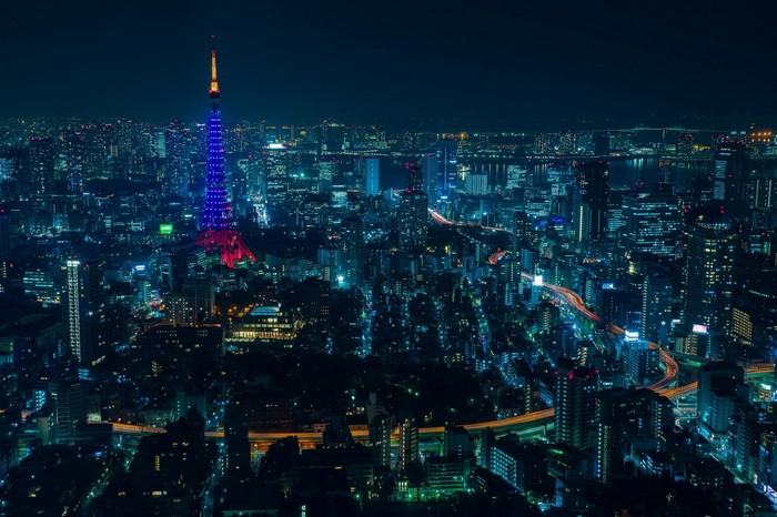 Tokyo Tower illuminated at night over a sprawling cityscape
