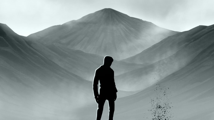 Man standing in front of misty mountains