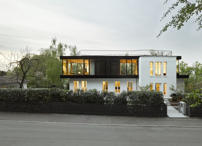 Modern white house with glass-enclosed upper floor