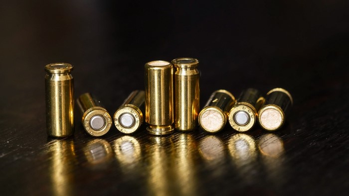 Brass bullet casings on a dark wooden surface