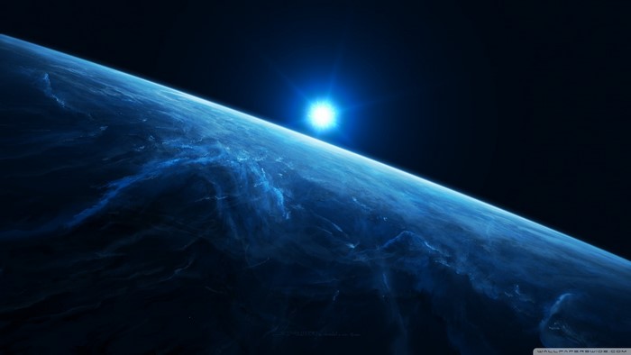 Planet with a bright sun rising over its horizon