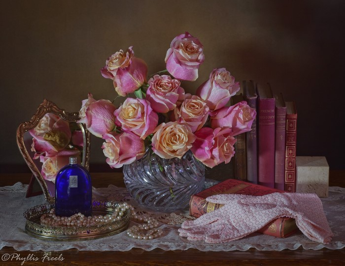 Still life with pink roses, books, and perfume bottle