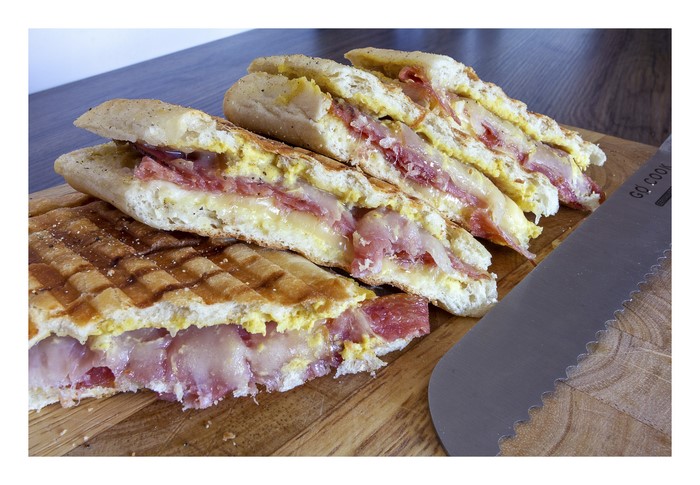 Panini sandwich with meat and cheese on a cutting board