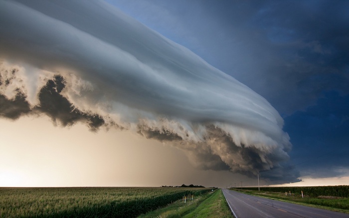 Shelf cloud over a rural road and field