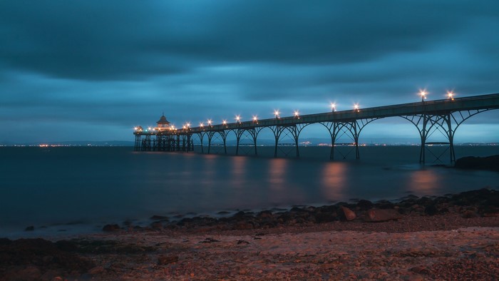 Pier with lights over water at night