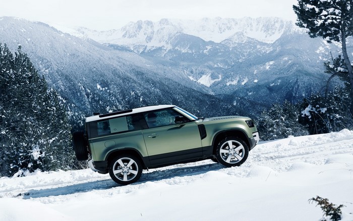 Land Rover Defender driving in snowy mountains