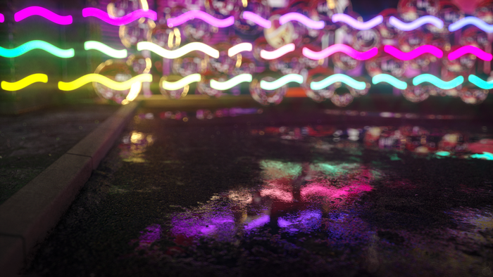 Wavy neon lights reflected on wet asphalt