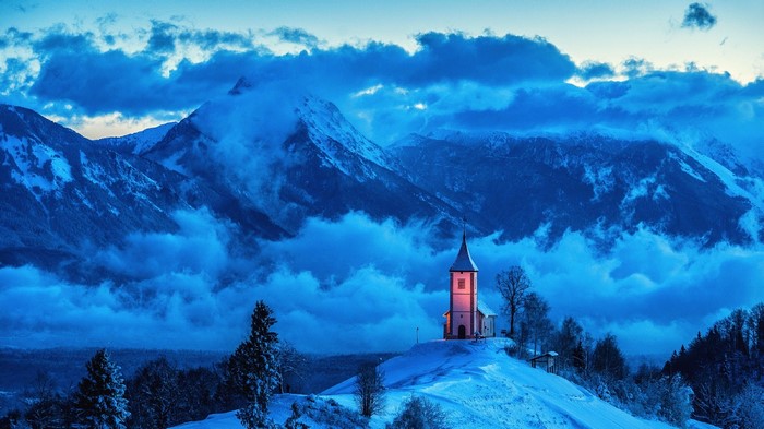Church on a snowy hill in the mountains of Slovenia