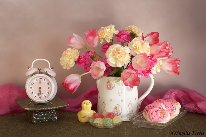 Still life with alarm clock, flowers, and cookies