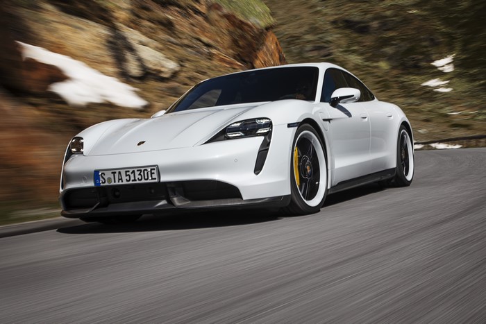 White Porsche Taycan driving on a mountain road