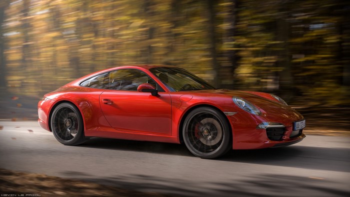 Red Porsche 911 driving on a road