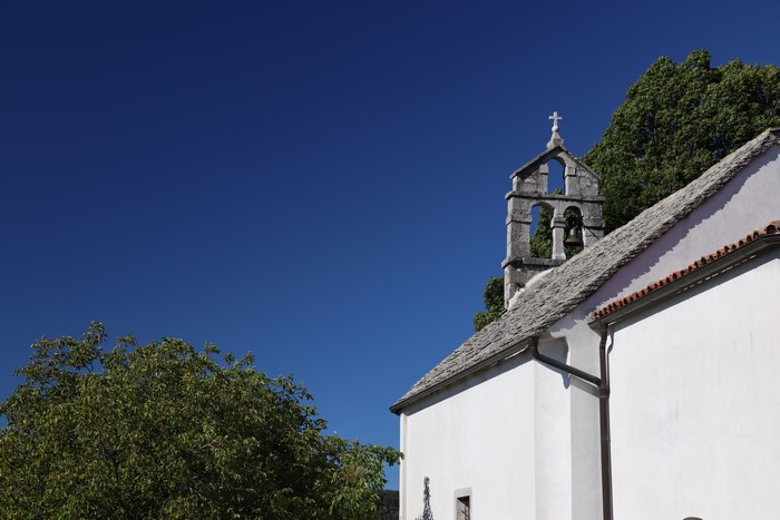 Church bell tower and roof against blue sky
