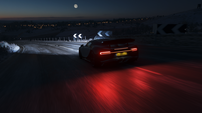 Bugatti Chiron driving on a snowy road at night in Forza Horizon 4