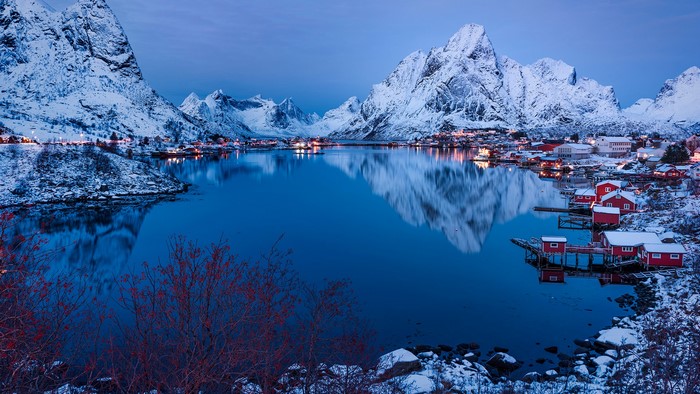 Snowy Lofoten mountains and fjord with red houses