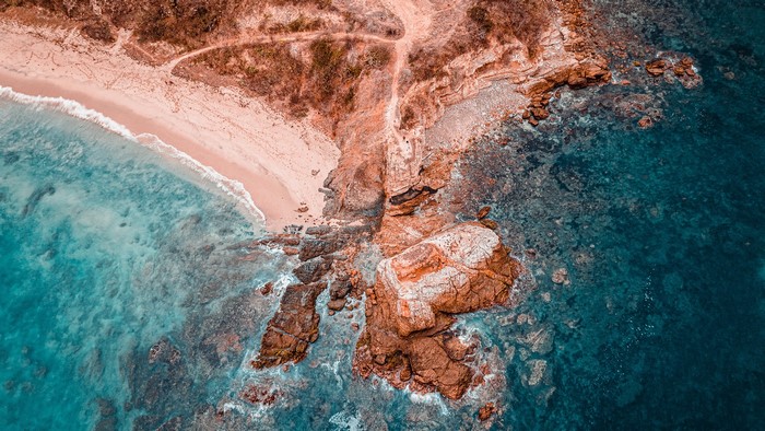 Aerial view of a rocky coastline and clear ocean water