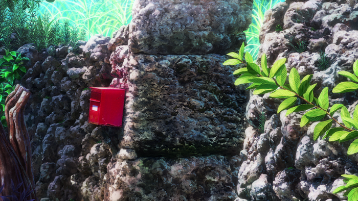 Red mailbox on a stone wall with plants