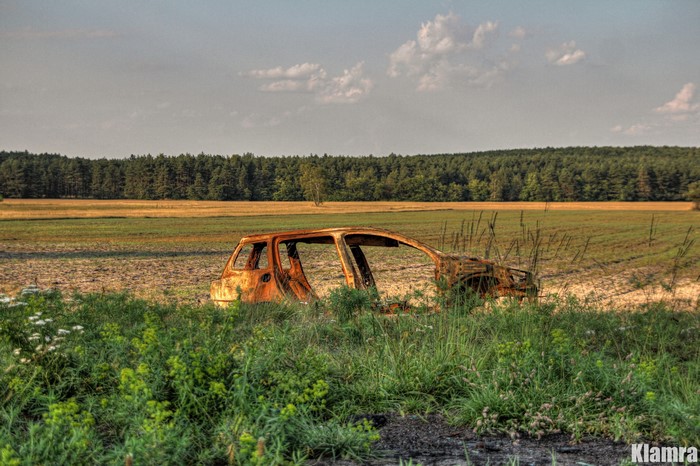 Abandoned car wreck in a field in Poland