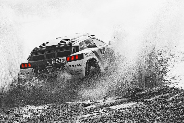 Peugeot 309 rally car driving through mud and water