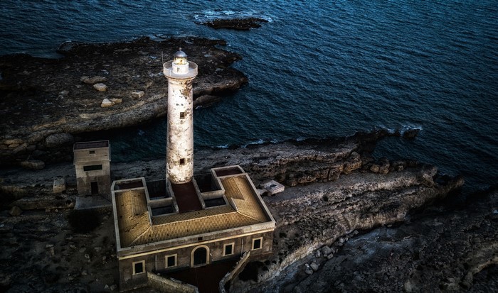 Lighthouse on rocky coast in Sicily, Italy
